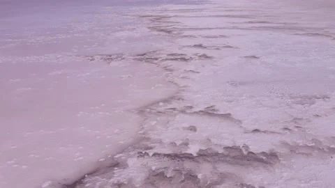 Aerial view of thick layer of salt deposits in coastal zone and pink water in Stock Footage 195932487