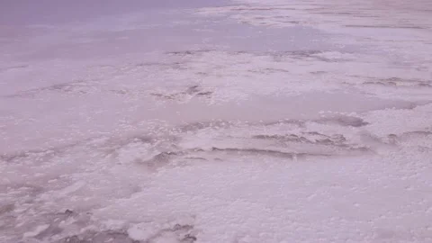 Aerial view of thick layer of white salt deposits in coastal zone and pink water Stock Footage 195932468