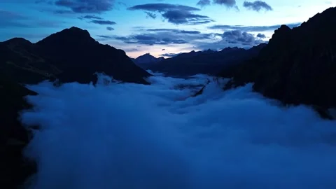 Aerial View Of Thick White Clouds Flowing Through Mountain Valley At Dusk Stock Footage 341657775