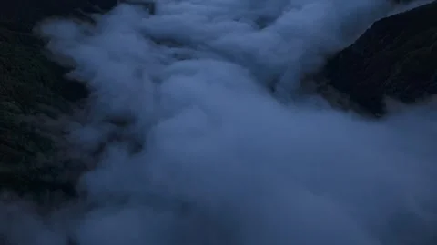 Aerial View Of Thick White Clouds Filling A Deep Mountain Valley At Dusk Stock Footage 341658035