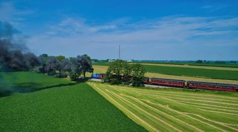 Aerial View of Thomas the Tank Engine Approaching Thru Trees and Farmlands Stock Photos