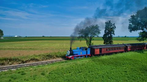 Aerial View of Thomas the Tank Engine Approaching Thru Trees and Farmlands Stock Photos