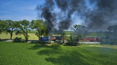 Aerial View of Thomas the Tank Engine Approaching Pulling Passenger Cars Blowing Foto stock