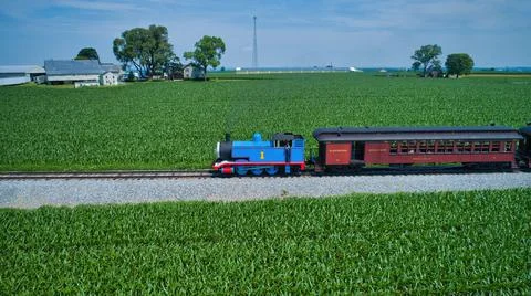 Aerial View of Thomas the Tank Engine Approaching Thru Trees and Farmlands Stock Photos
