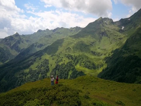 Aerial view. Three girls hikers look at the mountain Stock Footage
