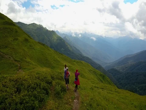 Aerial view. Three girls hikers look at the mountain Stock Footage