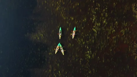Aerial View of Three Kayaks in Triangular Formation on Dark Water Stock Footage 296511697