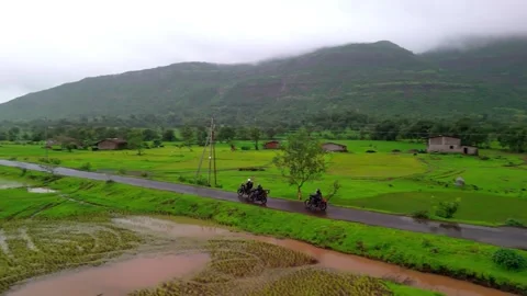 Aerial View of Three People with a Motorcycle Standing in the Foreground Stock Footage 342701657