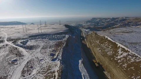 Aerial view of three suvs moving along the highway in the desert in winter Stock Footage 80243364