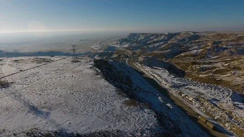 Aerial view of three suvs moving along the highway in the desert in winter Stock Footage 80243455