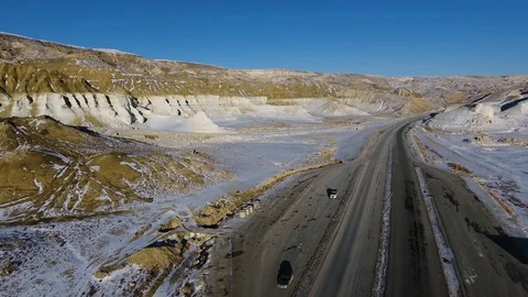 Aerial view of three suvs moving along the highway in the snow-coversd sandy Stock Footage 80245800