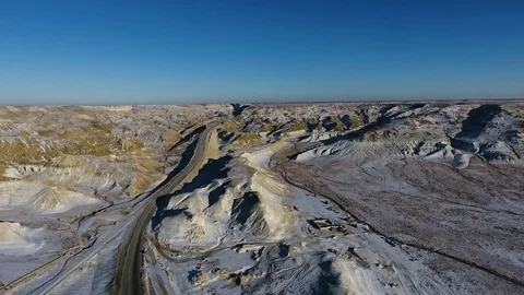 Aerial view of three suvs moving along the highway in the snow-coversd sandy Stock Footage 80245895