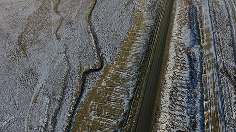 Aerial view of three suvs moving along the highway in the snow-coversd sandy Stock Footage 80984223