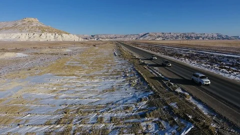 Aerial view of three suvs moving along the highway in the snow-coversd sandy Stock Footage 80984450