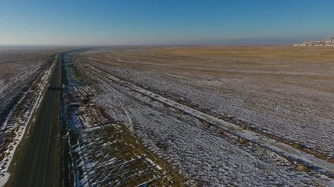 Aerial view of three suvs moving along the highway in the desert in winter Stock Footage 80986987