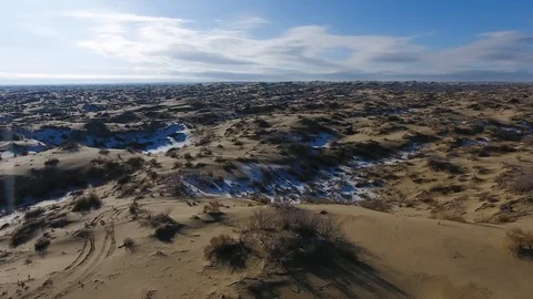 Aerial view of three suvs moving through the snow-covered desert in winter Stock Footage 93579839