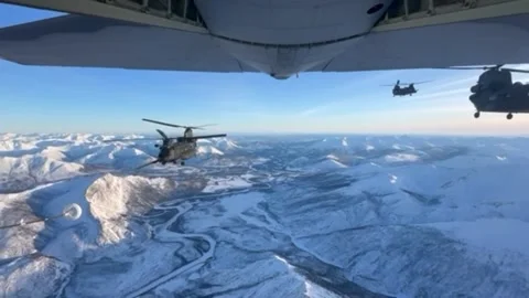 Aerial view of three U.S. Army MH-47G Chinooks flying over Alaskan wilderness Stock Footage 266993101