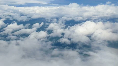 Aerial view through an airplane window. beautiful white clouds in blue sky Stock Footage 134687087