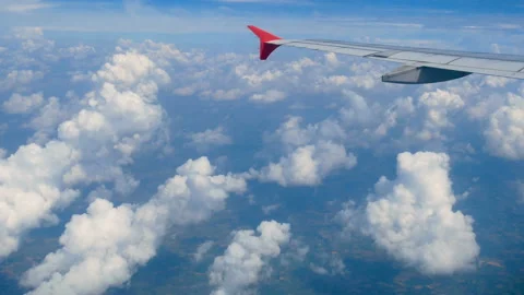 Aerial view through an airplane window. wing airplane and beautiful white clouds Stock Footage 134932367