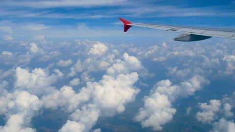 Aerial view through an airplane window. wing airplane and beautiful white clouds Stock Footage 135040937