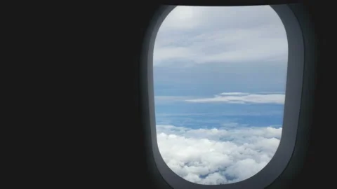 Aerial view through an airplane window. beautiful white clouds in blue sky Stock Footage 135302907