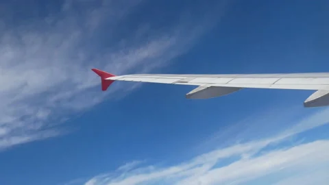 Aerial view through an airplane window. wing airplane and white clouds blue sky Stock Footage 238824183