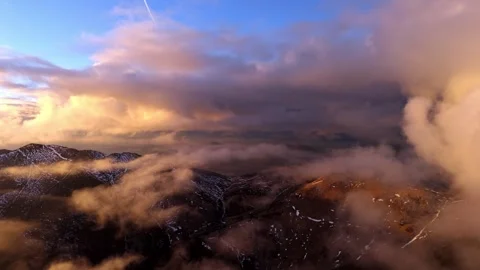 Aerial View through Clouds above Mountains at Golden Sunset Video stock 327594453