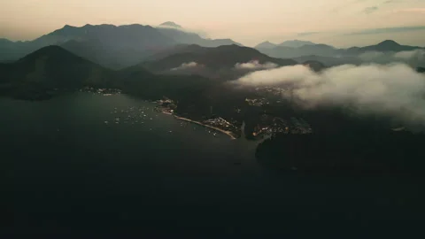Aerial View, Through Clouds Overlooking a Beach and Mountains, 4k Stock Footage 239688139