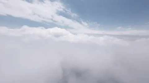 Aerial view through clouds showcasing expansive sky and fluffy formations Stock Footage 340516458