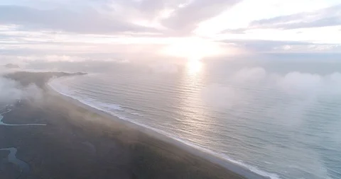 An aerial view through clouds towards the West Coast at Gillespie Beach. New Stock Footage 100126970