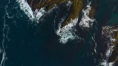 Aerial view through the clouds of the waves crashing on rocks. Stock Footage 147405302