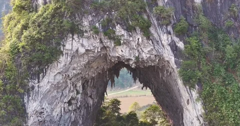 Aerial View Through Mountain Eye Rock Arch in Cao Bang Vietnam Stock Footage 332016659