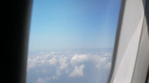 Aerial view through plane window with view over puffy white cloud with clea.. Stock Footage 246469340