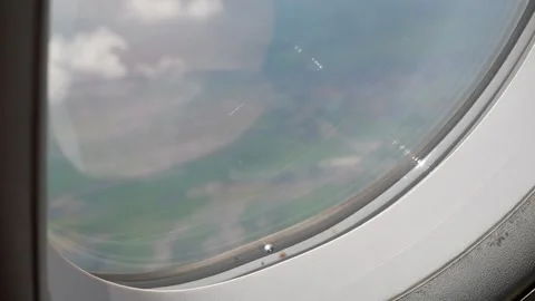 Aerial view through plane window frame over puffy white cloud while flying .. Stock Footage 285298507