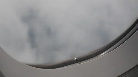 Aerial view through plane window frame over puffy white cloud while flying .. Stock Footage 294917351