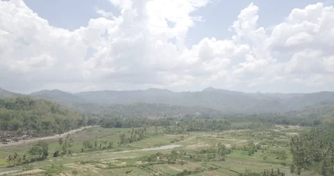 Aerial view tilt down and backward of nice rice fields in valley under the mo Stock Footage 121545163