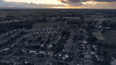 Aerial view, tilt up move. Dramatic sunset over residential area of small tow Stock Footage 95563462