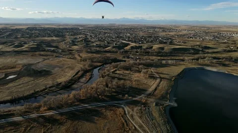 Aerial view tilting up shot, paramotor ascending above the sky in rural Stockbeeldmateriaal 146882264