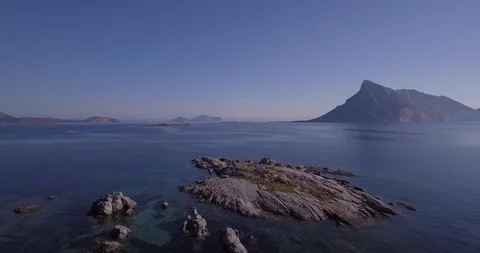 Aerial, a view on a tiny stone island in the middle of Mediterranean sea in S Stock Footage 102891428