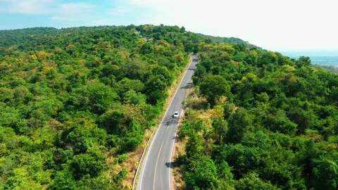 Aerial view from top to bottom of a white car driving on a mountain country road Video stock 166456185