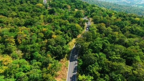 Aerial view from top to bottom of a white car driving on a mountain country road Video stock 166456593