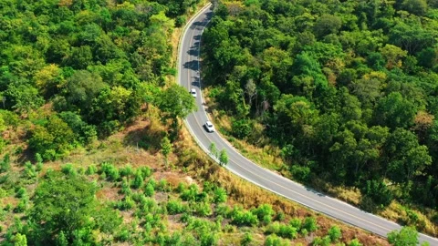 Aerial view from top to bottom of a white car driving on a mountain country road Video stock 166456799