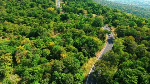 Aerial view from top to bottom of a white car driving on a mountain country road Video stock 166457203