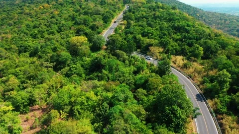 Aerial view from top to bottom of a white car driving on a mountain country road Video stock 166457427