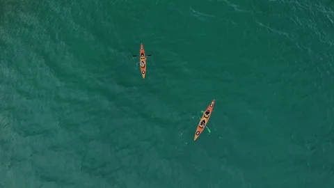 Aerial view top down from above as two couples paddle in sea kayak Stock Footage 118619518