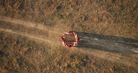 Aerial view: Top down view. A team of dancers circling in dance in the glade Stockbeeldmateriaal 94653526