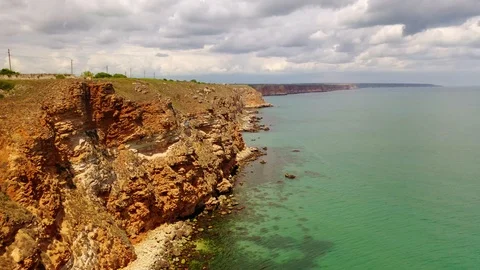 Aerial view of top down view of the red rocky coastline Stock Footage 109249490