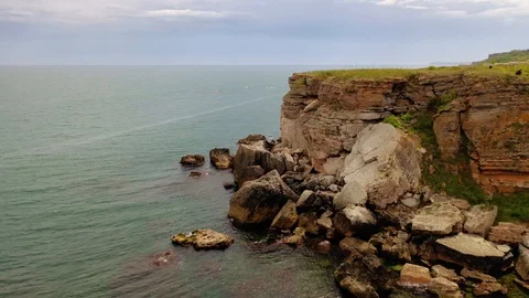 Aerial view of top down view of the red rocky coastline Stock Footage 109249641