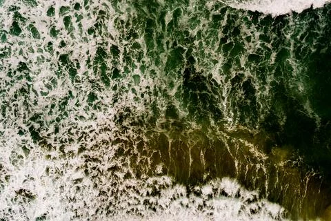 Aerial view Top down Waves crashing on sandy shore,Dark sea surface in summ.. Stock Photos