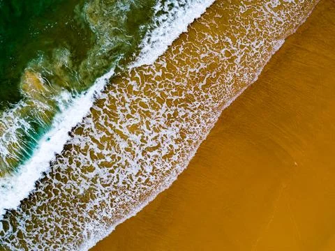 Aerial view Top down Waves crashing on sandy shore,Dark sea surface in summ.. Stock Photos